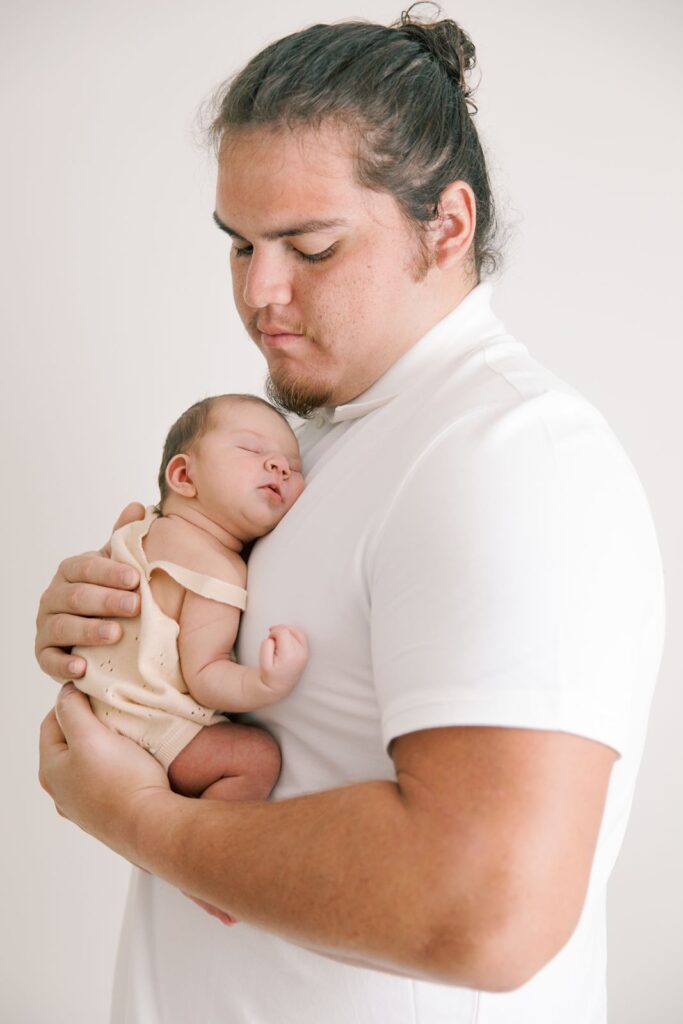 dad with newborn baby in a photography studio