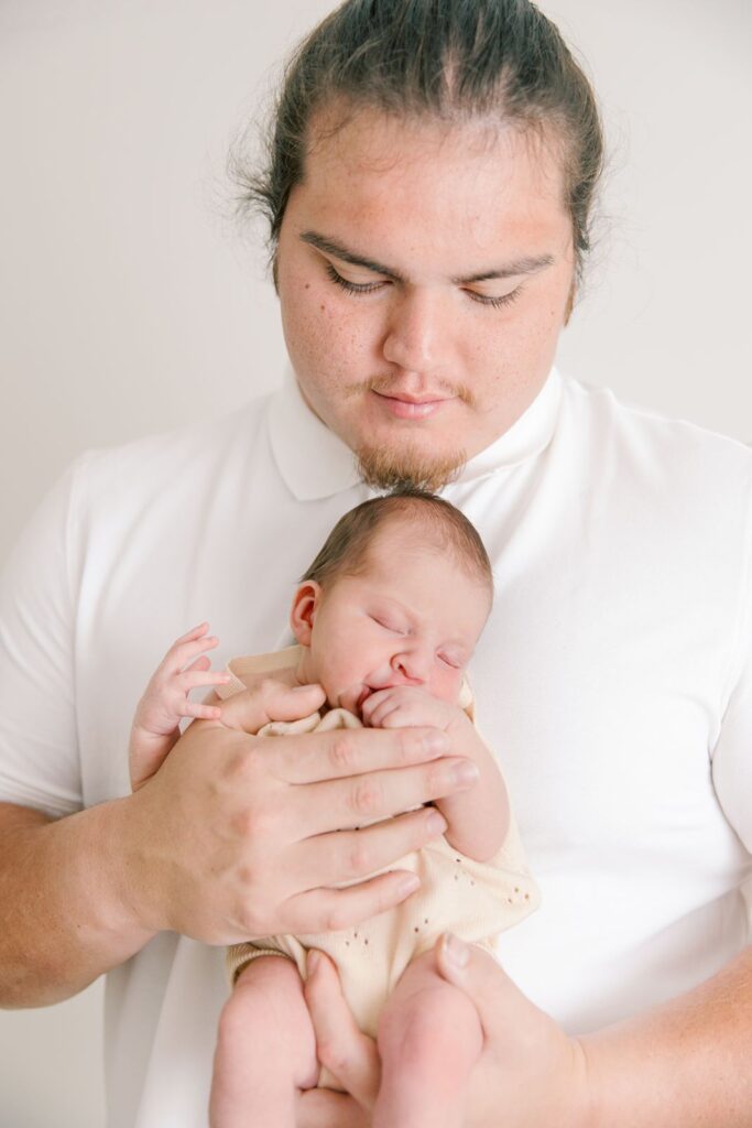 dad with newborn baby in a photography studio